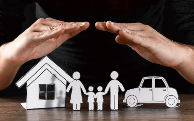 Manos protegiendo familia y propiedad asegurada tras siniestro